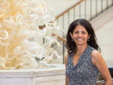 Patty Rodriguez Brennan, Associate Professor of Biological Sciences,Mount Holyoke College, stands in front of glass sculpture. Photo courtesy of Mount Holyoke College